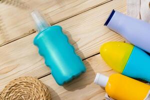 Sunscreen cream bottles in beach bag on wooden background photo