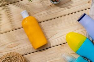 Sunscreen cream bottles in beach bag on wooden background photo