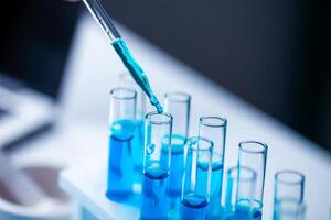 A person is pouring blue liquid into a series of test tubes. The tubes are lined up on a table, and the liquid is being poured into the first one. Concept of precision and scientific experimentation photo