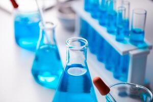 A collection of blue glass beakers and test tubes on a table. The blue color of the beakers and test tubes gives a sense of calmness and serenity photo
