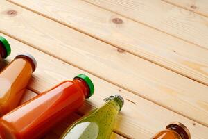 Juice bottles on wooden background flat lay photo