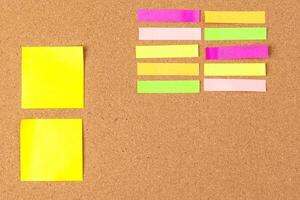 Cork board with several colorful blank notes with pins photo