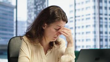 Exhausted overwhelmed businesswoman with a headache trying to meet project deadline, working hard to save the reputation of her corporation. Stressed nervous leader in crisis, overload. Camera A. video