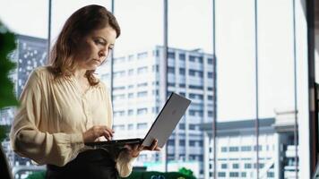 Businesswoman with leadership skills creates a financial report, demonstrating her expertise in analysis, forecasting and ensuring the organizational stability within market conditions. Camera B. video