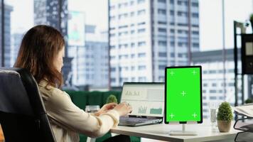General director using chroma key template on modern gadget, developing her business within the industry. Female entrepreneur with ambition in her high end corporate office. Camera B. video