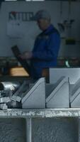 Metal parts on factory table with working assembler. Creative. Worker assembles factory machines with metal parts. Various metal parts for assembling factory machines video