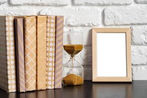 Books with picture frame on wooden table photo