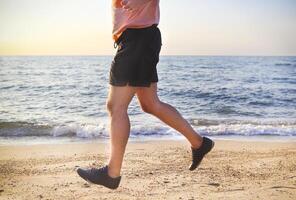 Man running on the beach at sunset photo