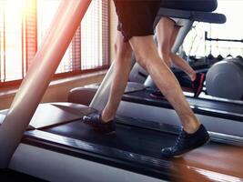 Healthy man and woman running on a treadmill photo