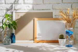 Photo frames on a brick wall background on the table with wheat ears in vase