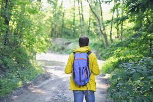 Man with backpack hiking in forest photo