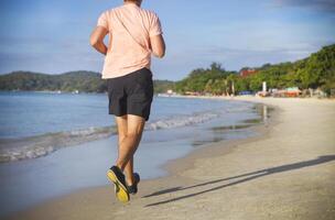 Man running on the beach at sunrise photo