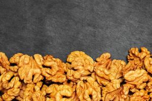 Walnuts. Walnut kernels on dark stone table. Top view photo