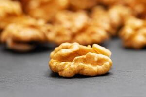 Walnuts. Walnut kernels on dark stone table. Vegetarian or healthy food photo