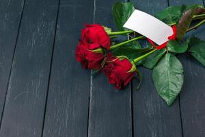 Red roses with message card. Valentines Day background photo