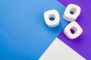 Rolls of toilet paper on color background, top view photo