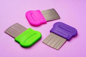 Three combs for removing lice and nits on lilac background photo