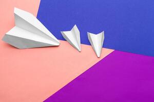 white paper airplane on a color block paper background photo