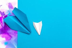 white paper airplane on a color block paper background photo