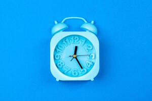 Alarm clock on color background. Pastel minimalism. Copy space photo