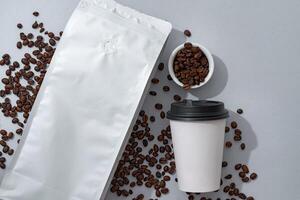 Cup of coffee with coffee beans on paper background. Top view photo