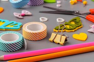 Crafting materials and tools arranged on a gray surface during a creative project photo