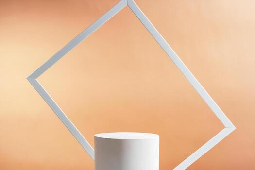 Minimalistic display of a white cylindrical object framed by a white rectangular border against a soft orange background photo