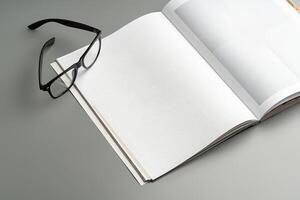 A blank open notebook resting on a neutral background during daylight photo