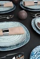 Table setting. Plates with abstract pattern on black table photo
