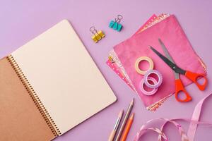 Scissors and decorative tape on colorful craft paper in a bright workspace photo