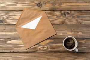 Vintage envelope with empty card, pen on wooden table top view photo
