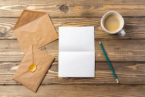 Vintage envelope with empty card, pen on wooden table top view photo