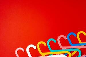 Hanger on red paper background. Minimalistic fashion concept. Top view photo