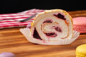 Meringue roll cake with cream on wooden table photo