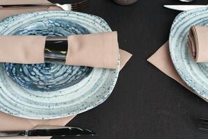 Table setting. Plates with abstract pattern on black table photo