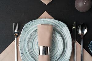 Table setting. Plates with abstract pattern on black table photo