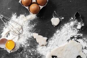 Preparation for baking. Eggs and flour on black background photo