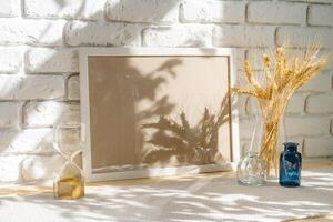 Photo frames on a brick wall background on the table with wheat ears in vase