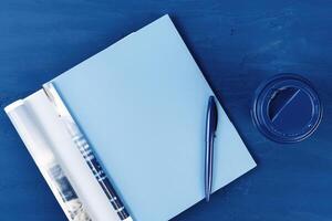 Top view of open magazine page with copy space on classic blue background photo