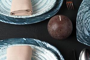 Table setting. Plates with abstract pattern on black table photo