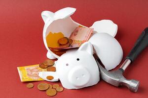 Broken piggy bank with ukrainian money notes and coins. Decline in living standards concept photo