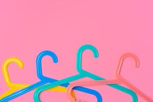 Flat lay composition with empty hangers on pink background photo