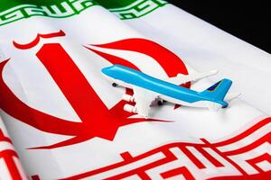 Small toy plane on a flag of Iran photo