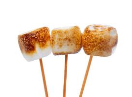 Grilled marshmallows on sticks isolated on white photo