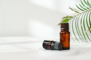 Aromatic Essential Oil Bottle With Dropper on White Surface in Bright Natural Light photo