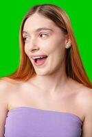 Young Woman With Surprised Expression in Front of Green Screen photo