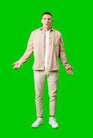Confused Young Man Standing Against Bright Green Background With Open Arms in Uncertain Gesture photo