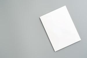 Empty White Sheet of Paper Positioned at an Angle on Light Gray Surface photo