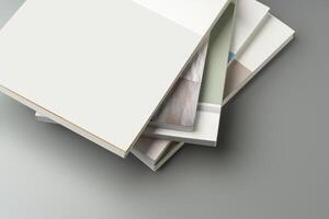 A stack of blank notebooks arranged neatly on a simple grey background photo