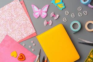 Crafting supplies arranged for a DIY project on a gray table with scissors, washi tape, and decorative items photo